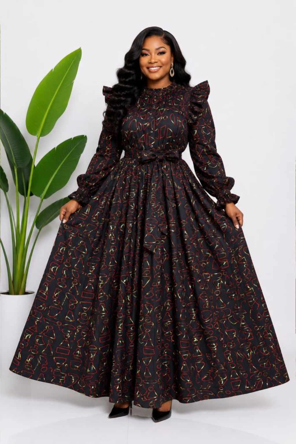 Woman wearing a black, red and gold abstract African print two-piece top and maxi skirt set