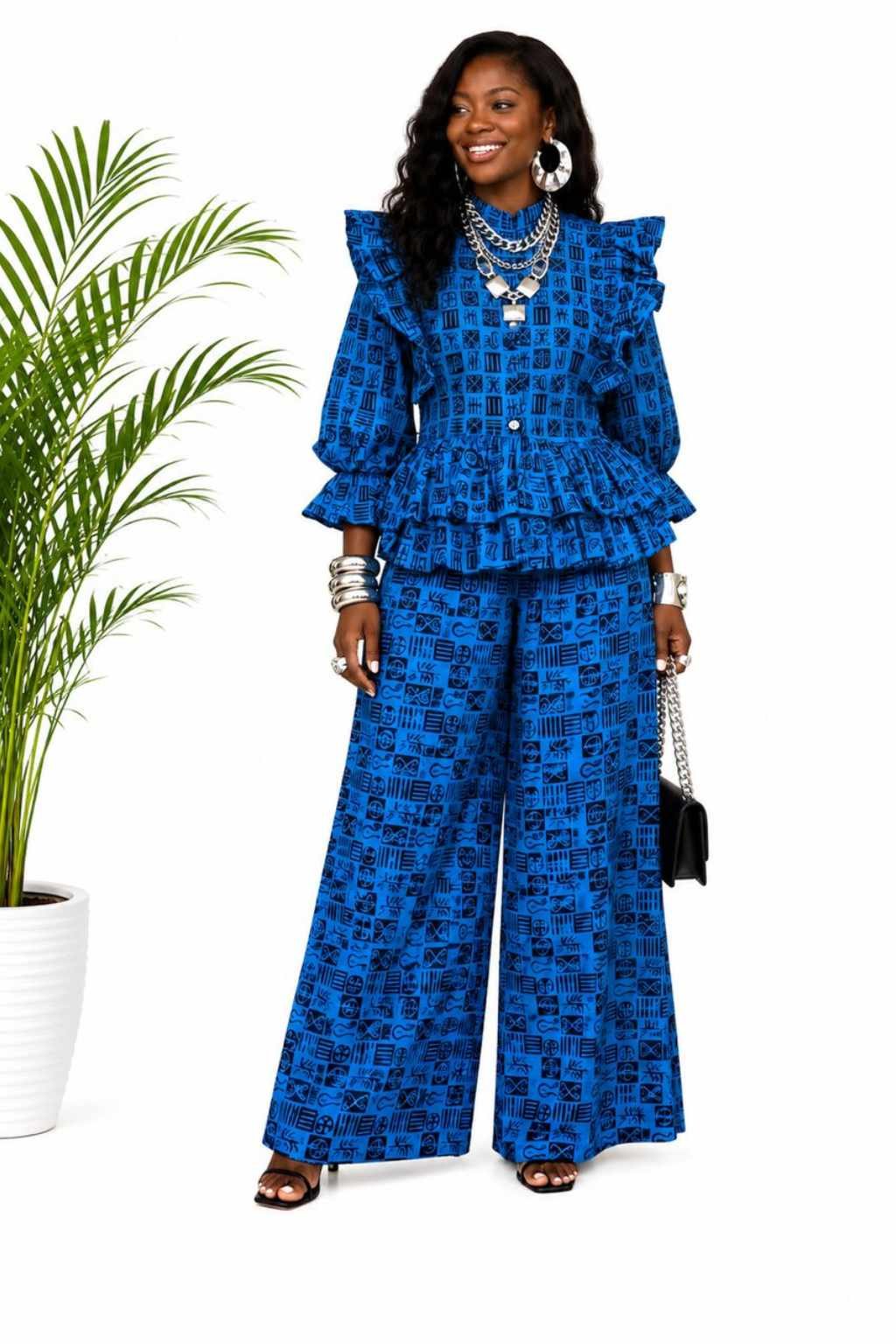 Woman wearing a cobalt blue and black tribal symbol African print peplum top and wide-leg pants set