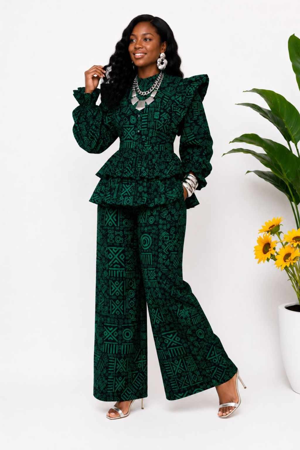Woman wearing a deep green and black tribal African print peplum top and wide-leg pants set