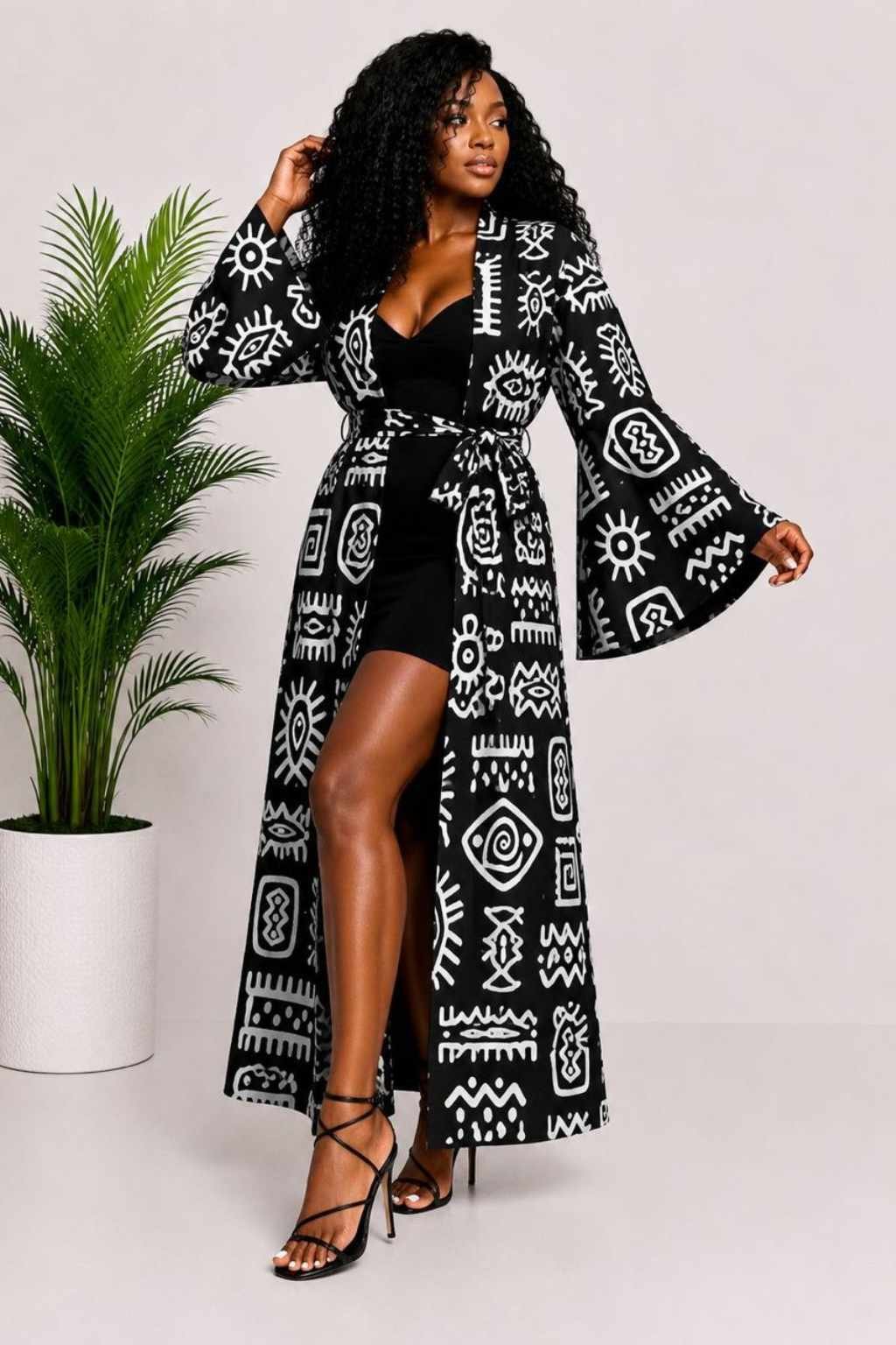 Woman wearing a black and white tribal symbol African print long kimono duster with bell sleeves