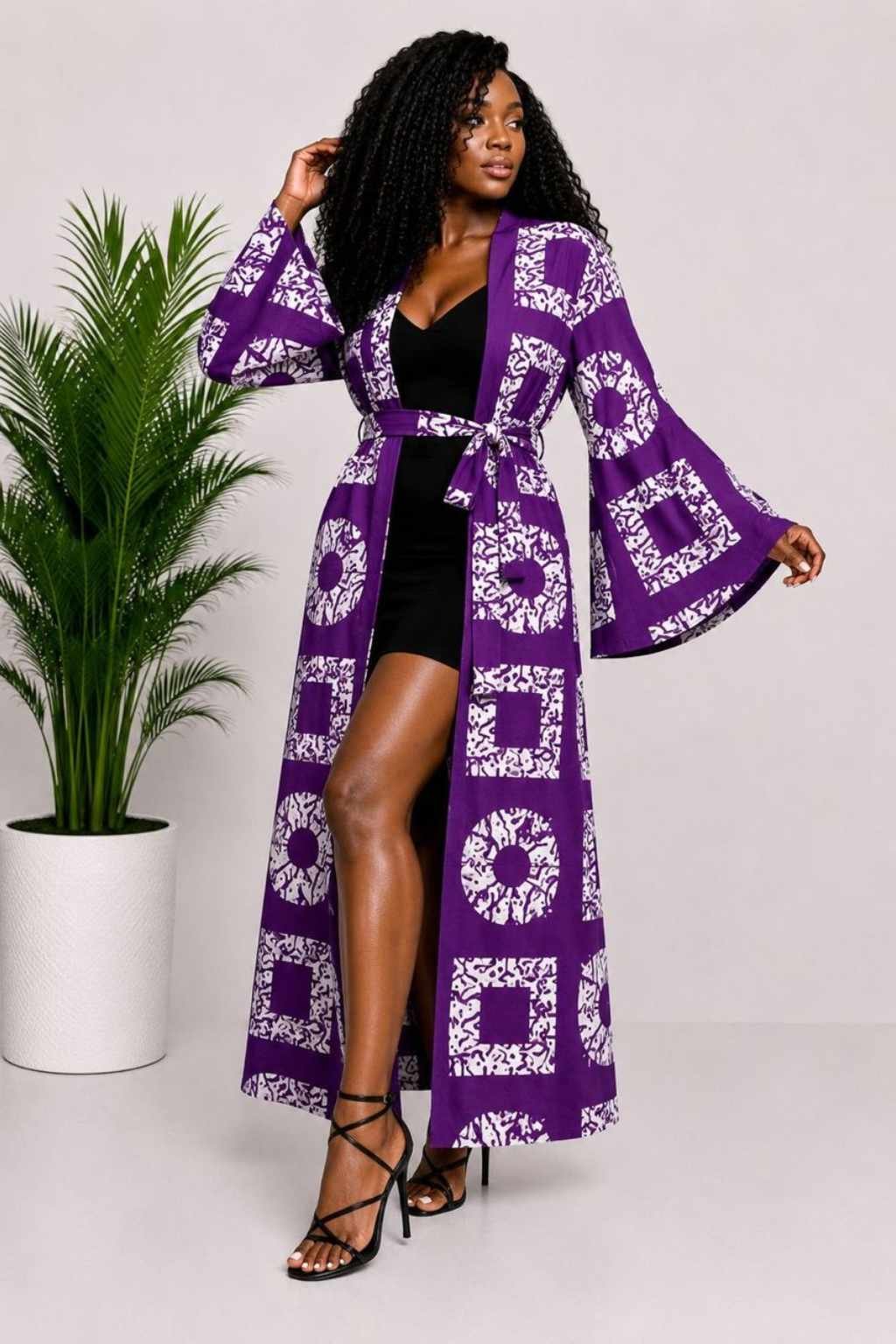 Woman wearing a purple and white batik squares African print long kimono duster with bell sleeves