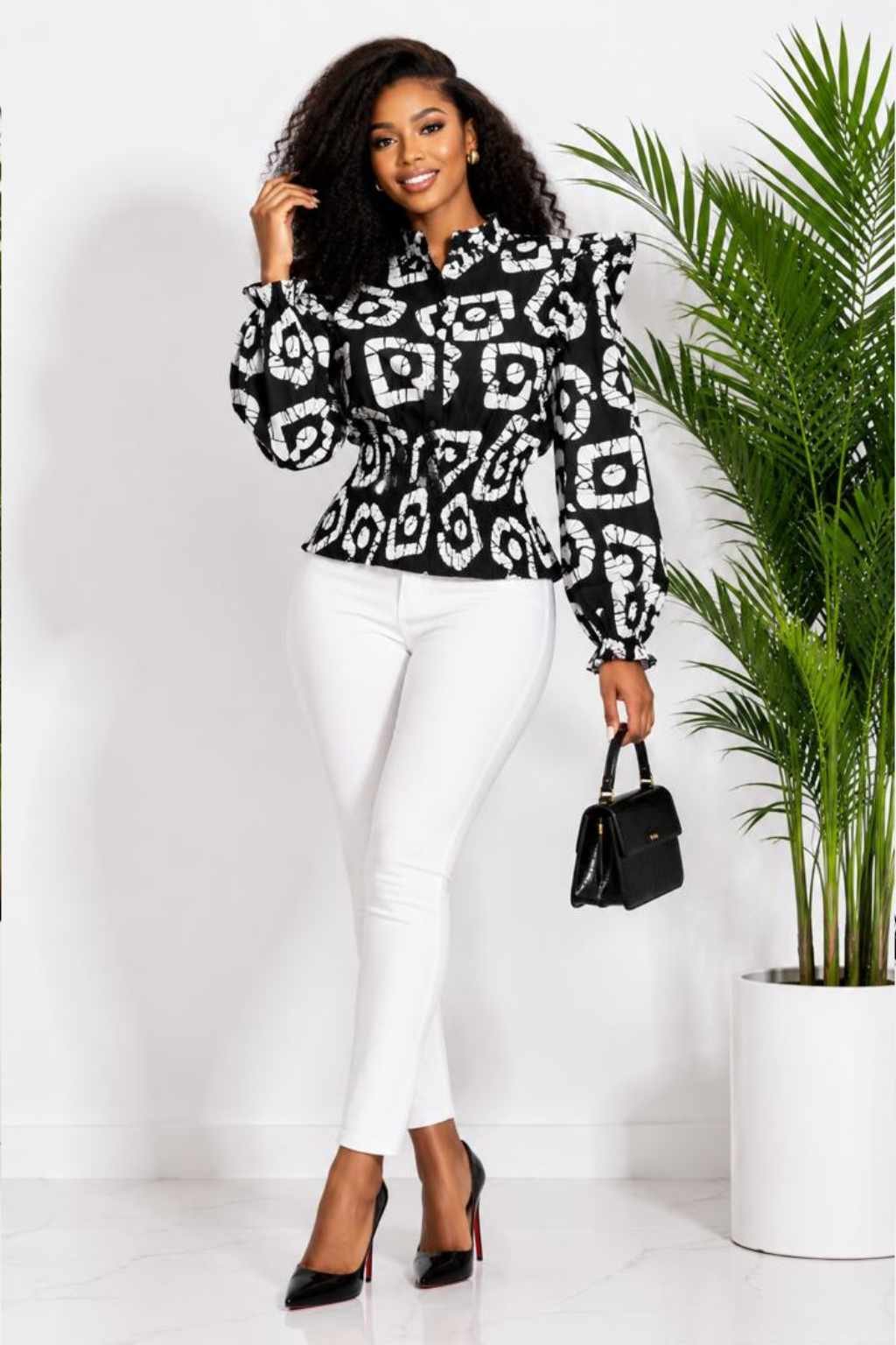 Woman wearing a black and white batik circle African print ruffle peplum top