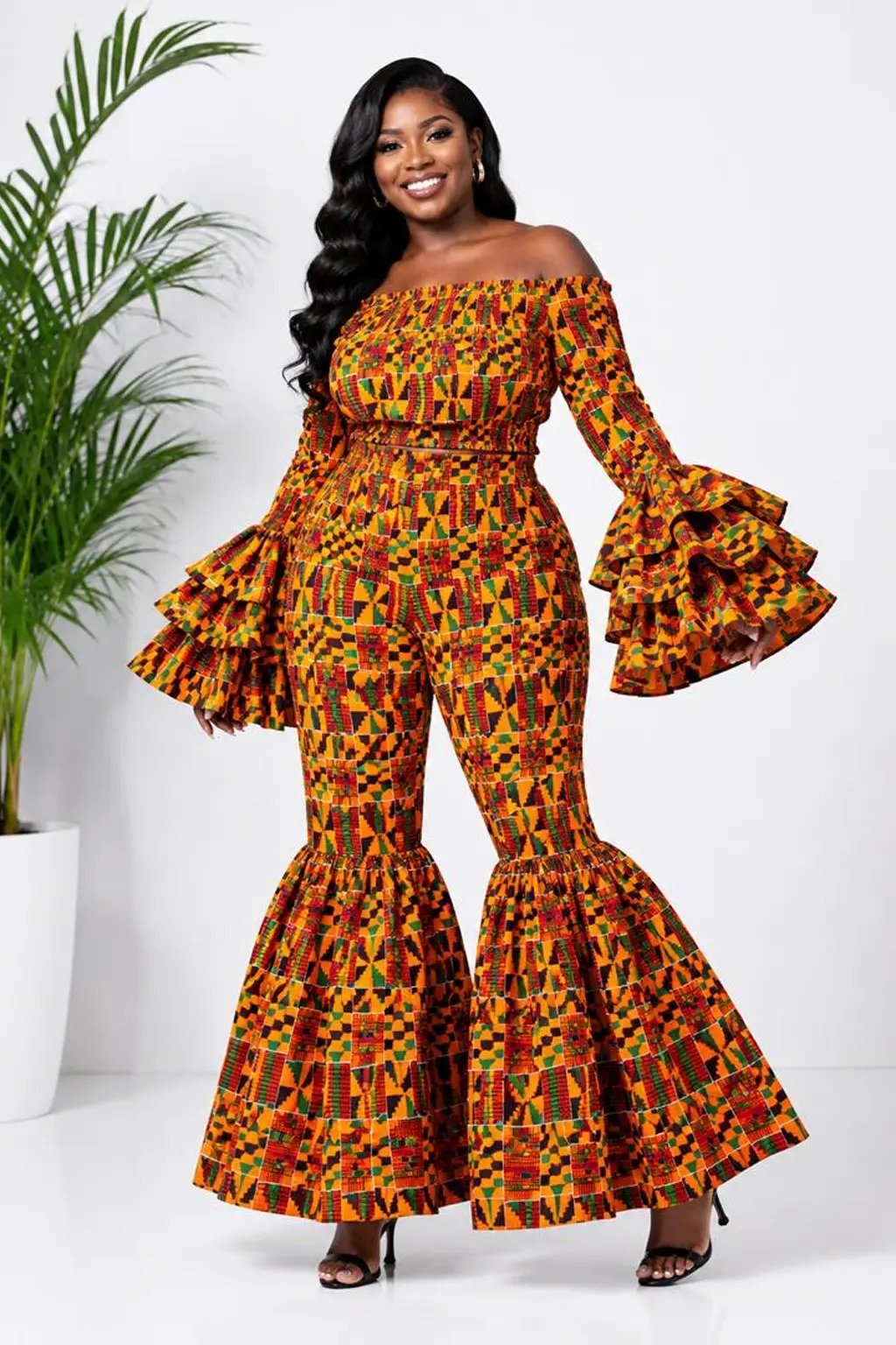 Woman wearing a kente African print off-shoulder bell-sleeve top and flare-leg pants set