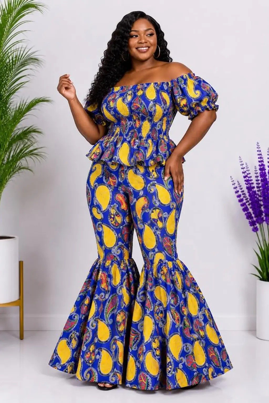 Woman wearing a blue and yellow paisley African print off-shoulder top and flare-leg pants set - view 2