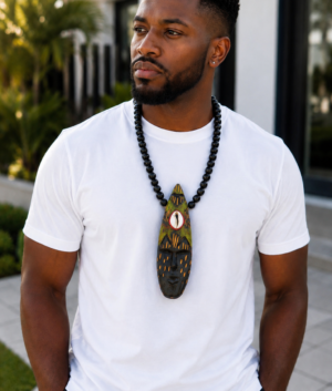 Man Wearing A Hand Carved African Mask Necklace, Wooden Statement Pendant, Black Beaded Tribal Choker, Men Unisex Cowrie Shell Jewelry And Authentic Artisan Gift.