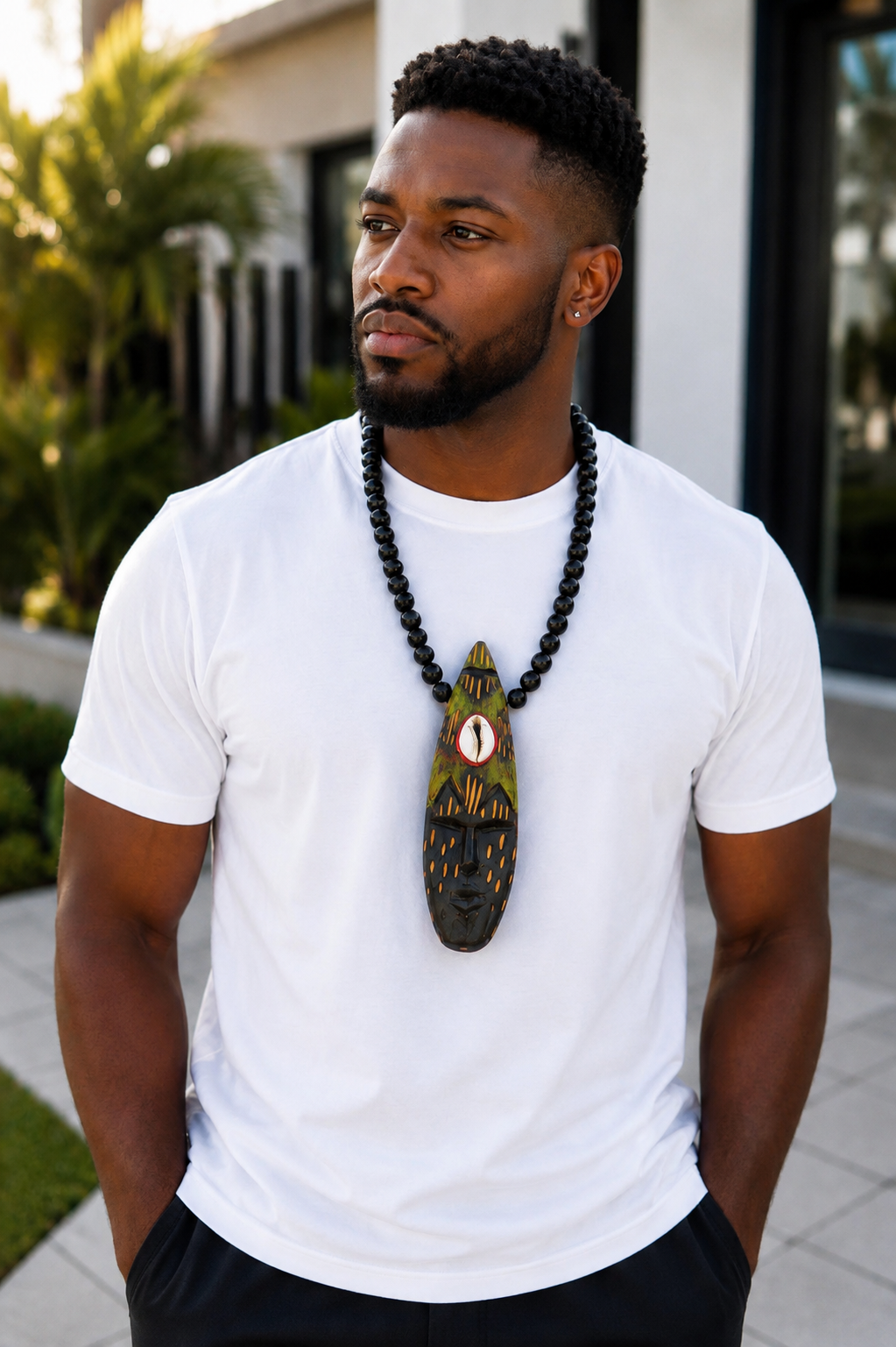 Man Wearing A Hand Carved African Mask Necklace, Wooden Statement Pendant, Black Beaded Tribal Choker, Men Unisex Cowrie Shell Jewelry And Authentic Artisan Gift.