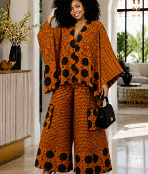 A Woman Wearing A Terracotta & Onyx Polka Dot Asymmetric Poncho And Wide-Leg Cargo Trousers Set.