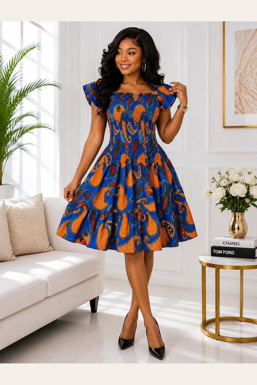 A Woman Wearing A Zaria Smocked A-Line Midi Dress – Royal Blue and Orange Paisley African Print.