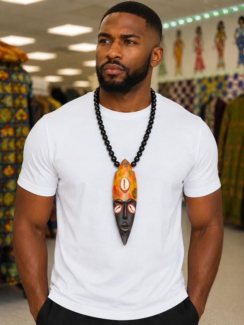 Hand Carved African Mask Necklace, Wooden Statement Pendant, Black Beaded Tribal Choker, Men Unisex Cowrie Shell Jewelry And Authentic Artisan Gift. 5 Man Wearing A Hand Carved African Mask Necklace, Wooden Statement Pendant, Black Beaded Tribal Choker, Men Unisex Cowrie Shell Jewelry And Authentic Artisan Gift.