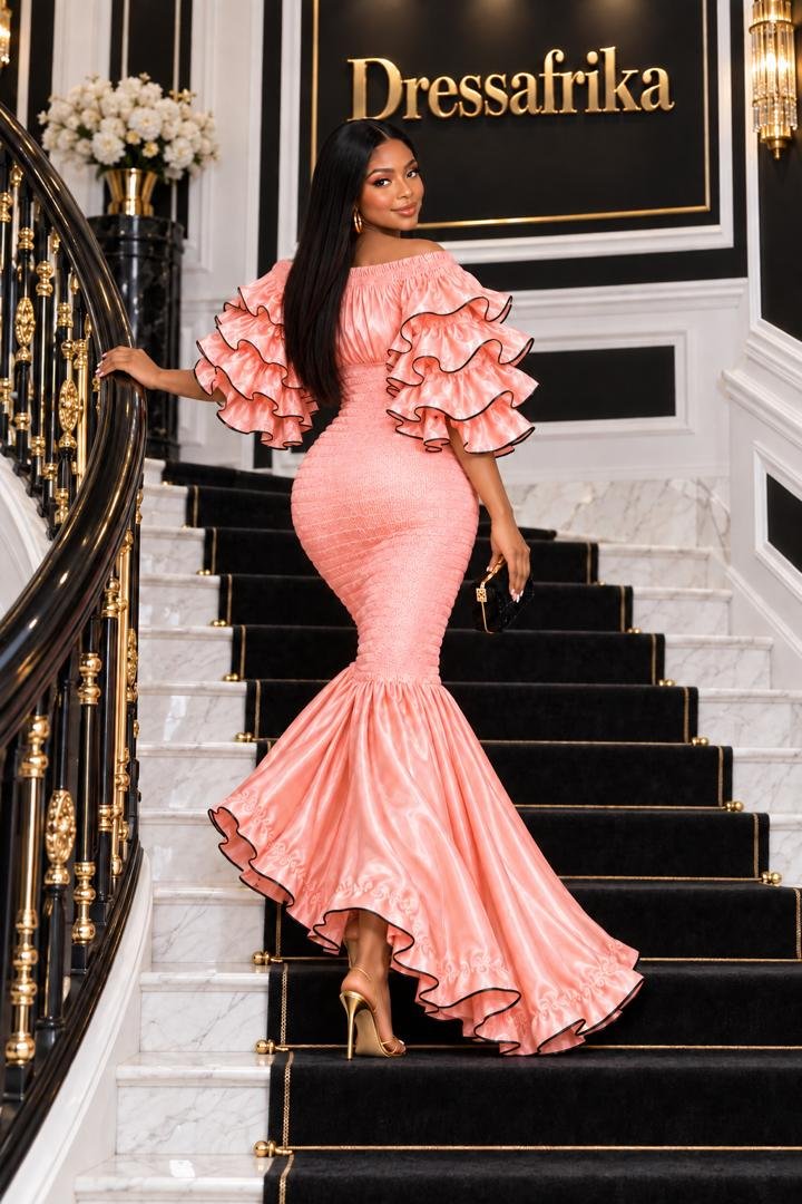 Elastic Peach Rose Gold Smocked Ruffle Mermaid Gown. 2 A Woman Wearing An Elastic Luminous Peach Rose Gold Smocked Ruffle Mermaid Gown.