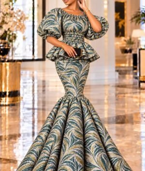 A Woman Wearing An Emerald Elastic Green & Gold Metallic Jacquard Smocked Peplum Mermaid Gown.