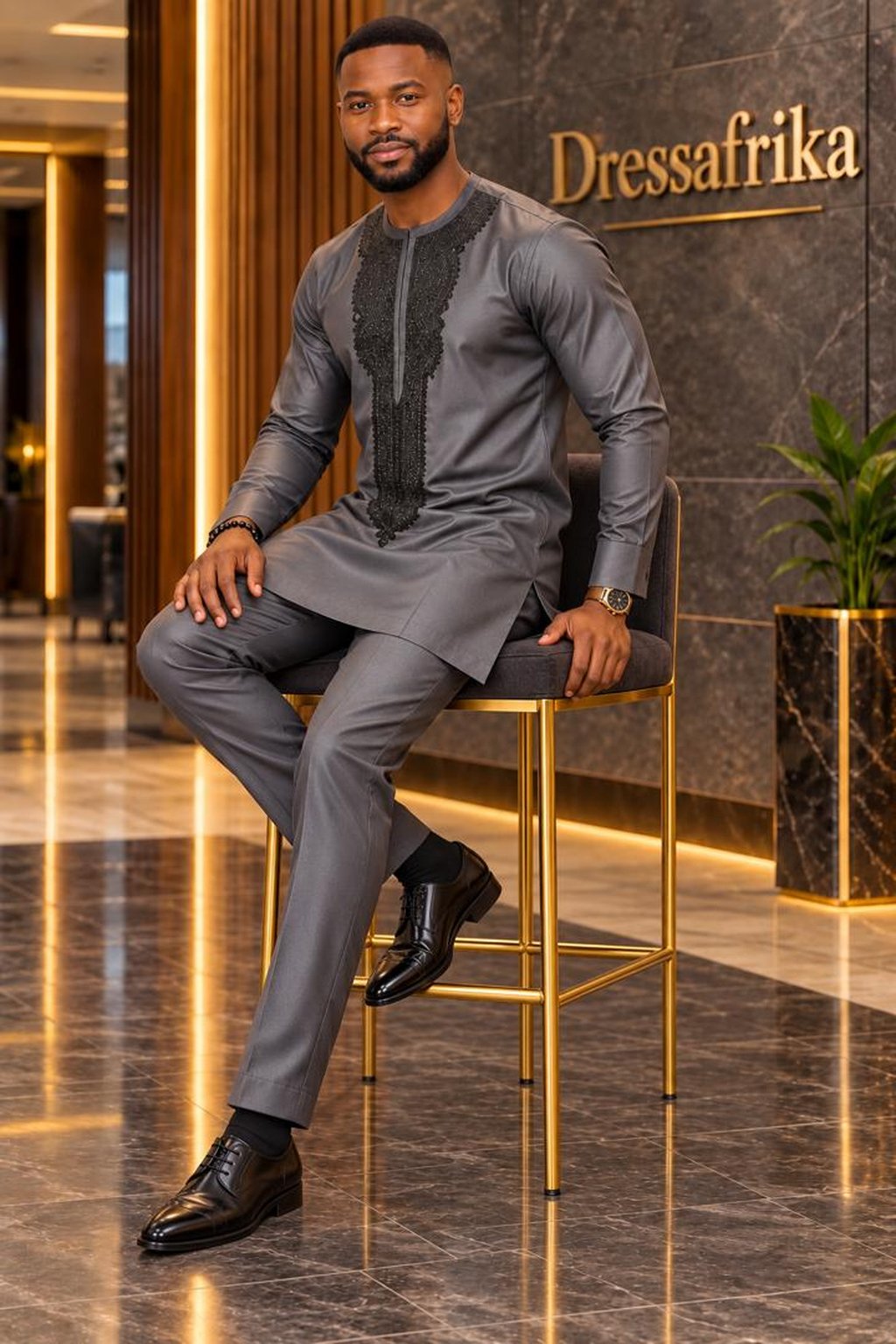 A Man Wearing A Charcoal Grey Embroidered Long-Sleeve Senator Tunic & Pants Set.